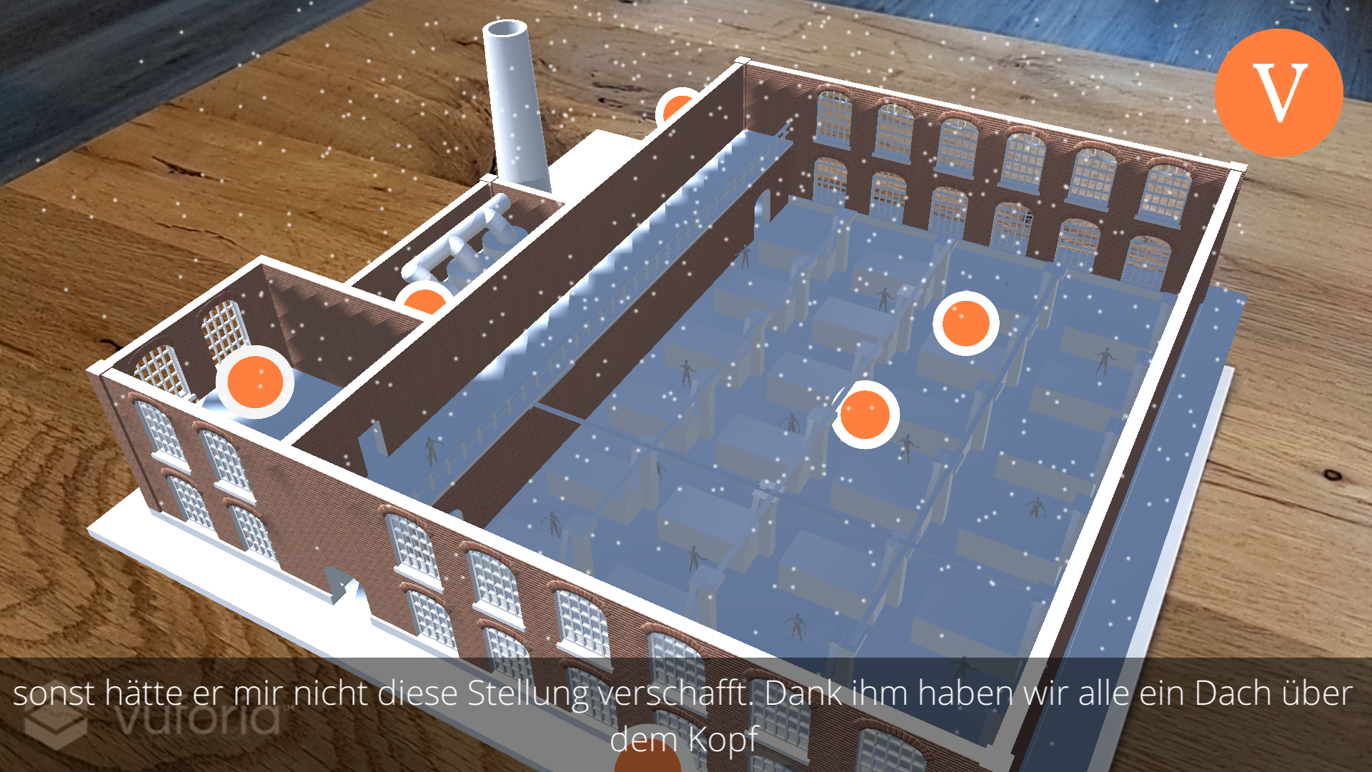 Screenshot of yARn that shows a 3D rendered factory projected on a wooden table from the perspective of the foreman. There are several orange colored points of interest inside the factory. At the bottom of the screen subtitles are displayed.